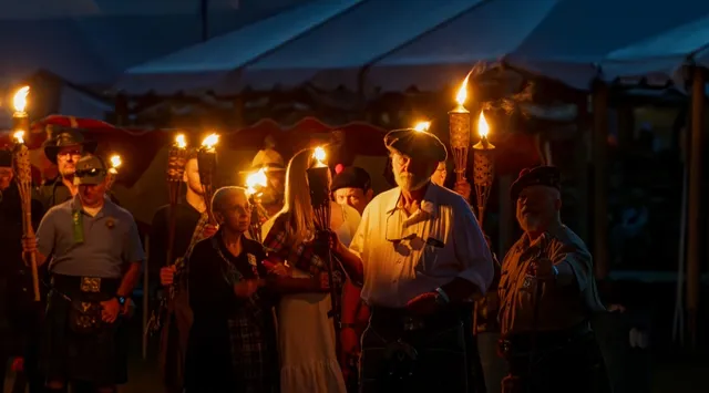 Clan members holding lit torches at dusk during the Grandfather Mountain Highland Games torch-lighting ceremony. Photo by Skip Sickler, courtesy of the Grandfather Mountain Stewardship Foundation.
